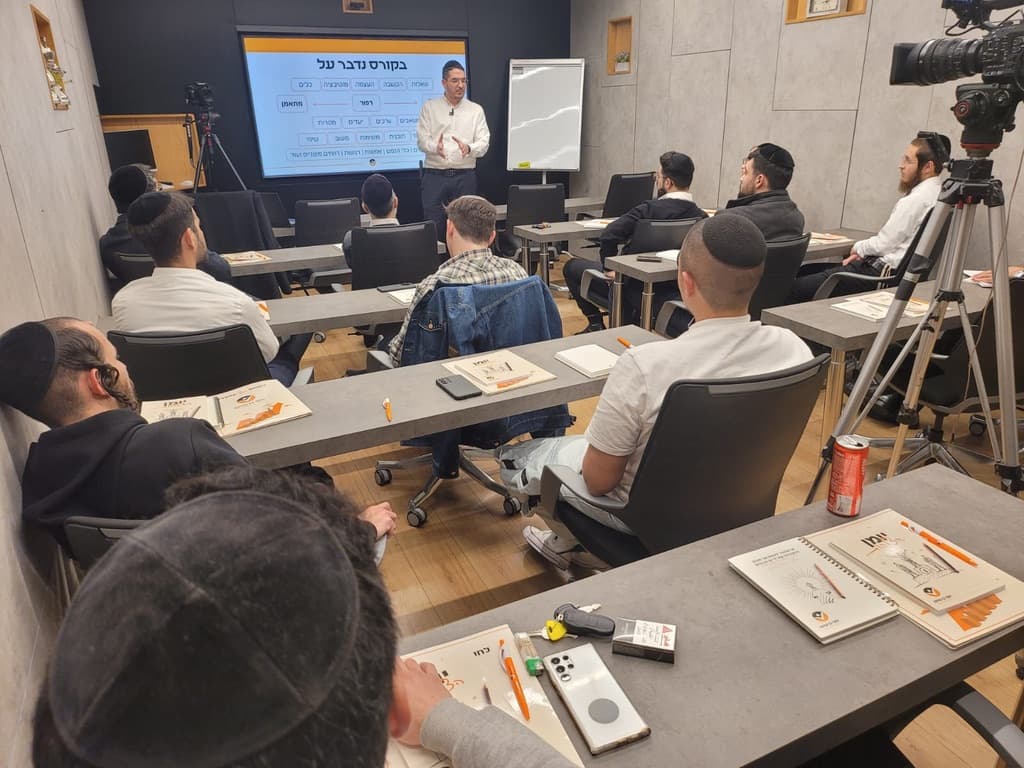 יוסף בן שושן מלמד את קבוצת ההכשרה מול מצגת ״בקורס נדבר על״, המשתתפים יושבים עם חוברות הקורס